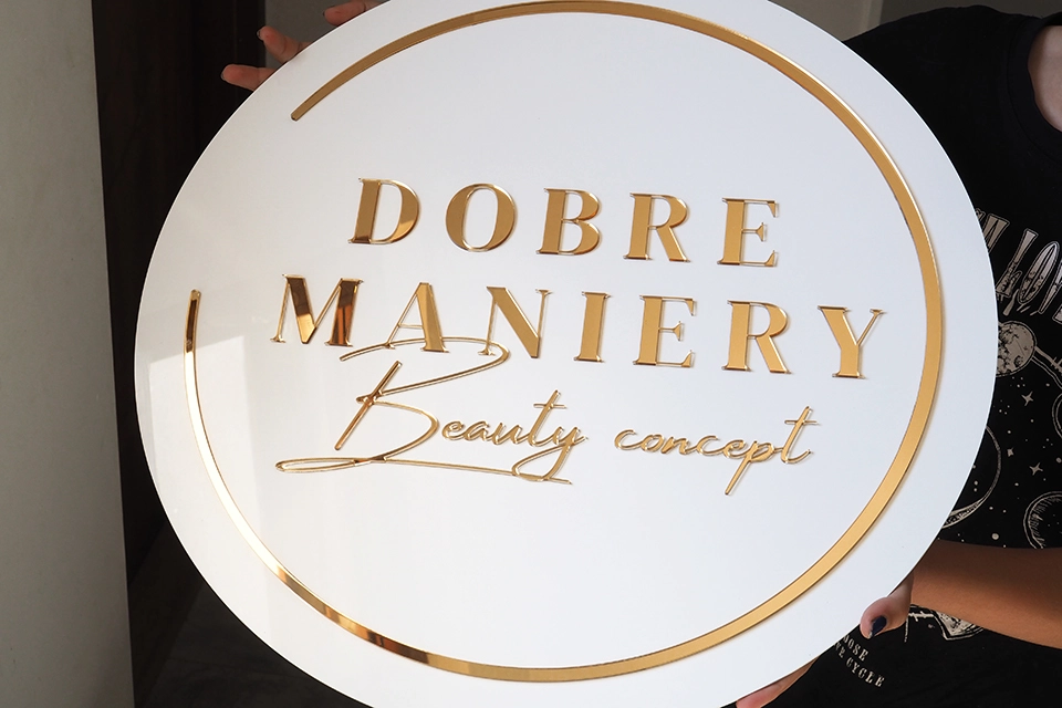 Okrągły szyld z ramką i złotym logo beauty
