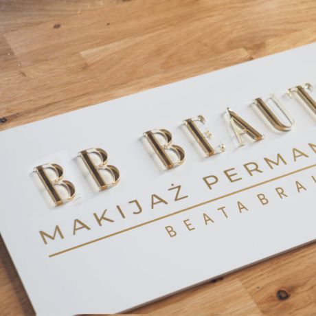 Tabliczka ze złotym logo firmy do salonu kosmetycznego Beauty